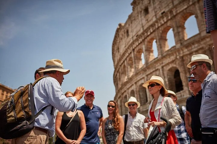 Guide speaking to visitors beside the Colosseum exterior