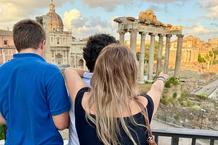 Visitors looking across the Roman Forum in warm afternoon light