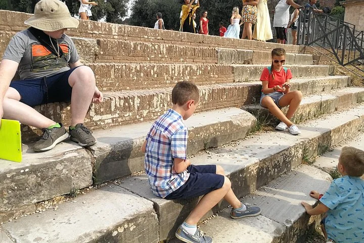 Children seated on ancient steps during an outdoor activity