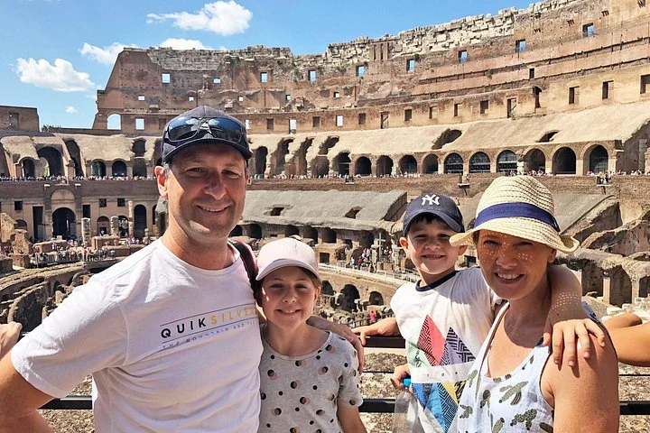 Adults and children at a sunlit Colosseum overlook
