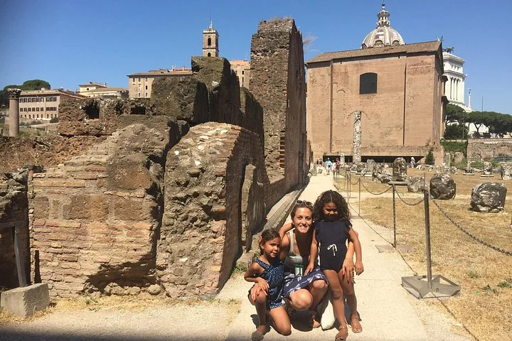 Visitors among Roman Forum ruins beneath a clear blue sky