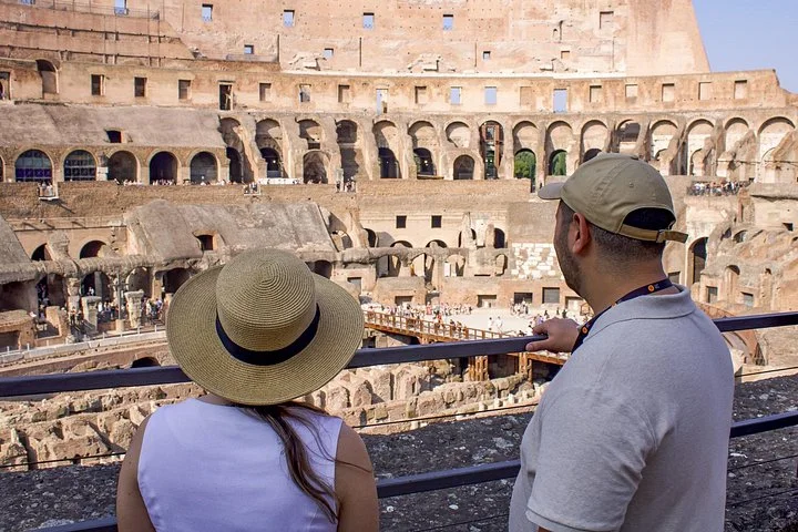 Two visitors looking into the Colosseum from a main-level overlook