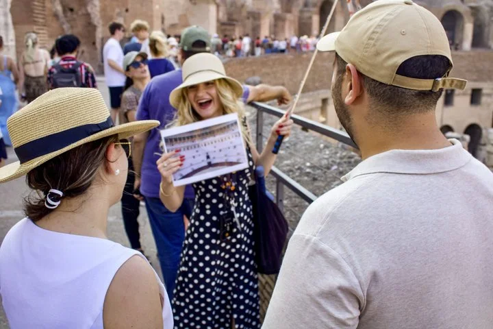 Guide using an illustrated sheet with visitors inside the Colosseum