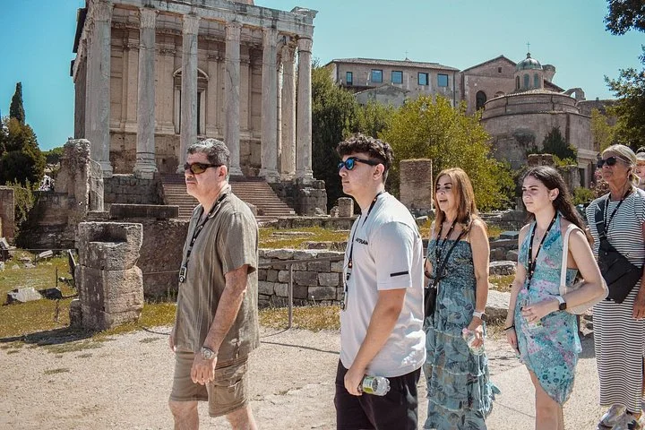 Visitors walking beside an ancient temple in the Roman Forum