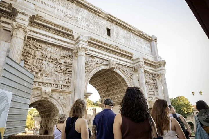 Visitors beside the carved Arch of Septimius Severus