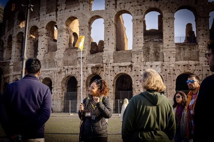 Guide speaking to visitors beneath the Colosseum arches