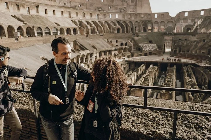 Guide and visitors at a main-level Colosseum overlook