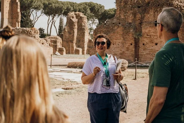 Guide speaking with visitors among Palatine Hill ruins