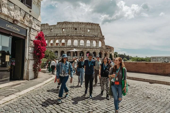 Visitors walking on a cobbled street with the Colosseum behind them