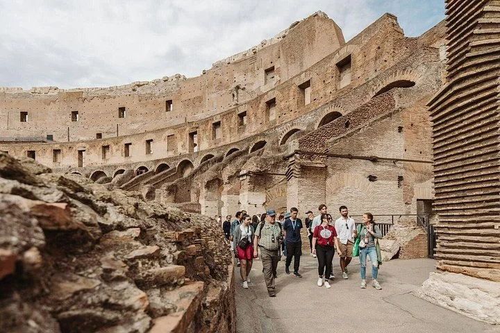 A guide speaks with visitors on a Colosseum walkway.