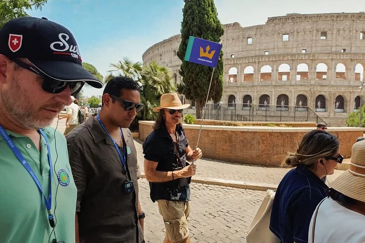 A Crown guide leads visitors along the outside of the Colosseum.