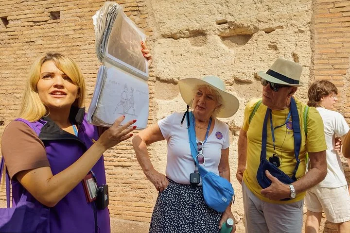 Guide using an illustrated sheet beside Colosseum masonry
