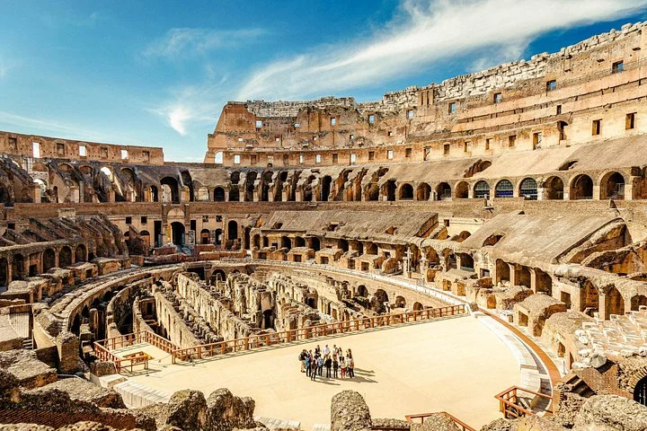 A wide view across the Colosseum arena platform and ancient stone walls.