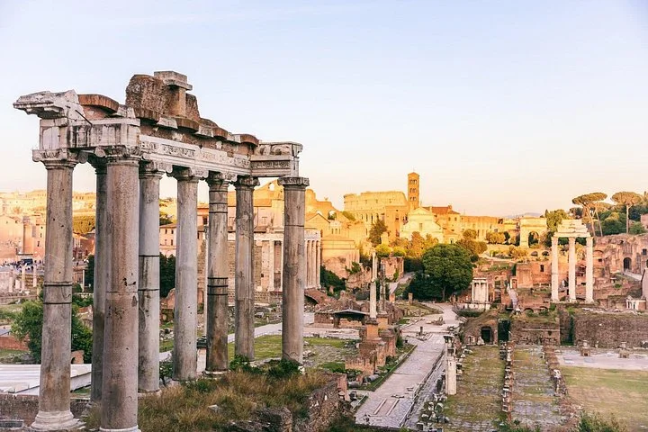 Ancient columns overlook the Roman Forum in warm evening light.
