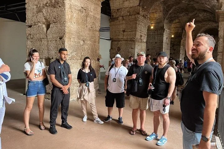 A guide explains the Colosseum beneath its stone vaults.