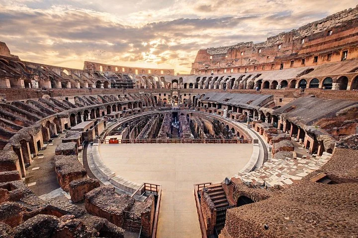 A glowing evening sky hangs over the Colosseum interior.
