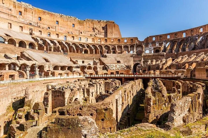 Sunlight illuminates the Colosseum's inner tiers and underground walls.
