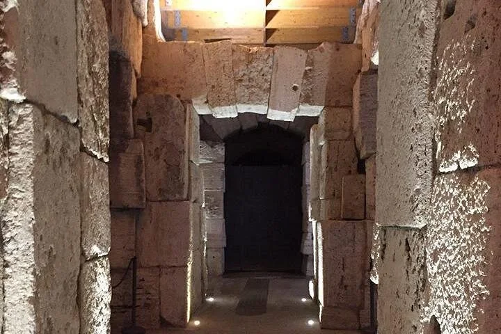 Stone pillars frame a quiet passage beneath the Colosseum arena.