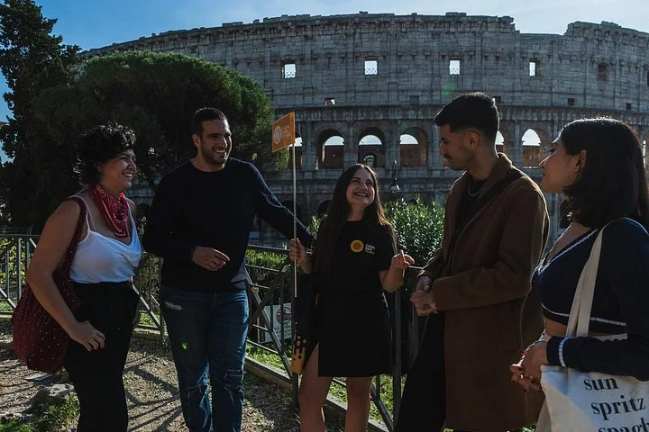 Guide and visitors on a terrace beside the Colosseum