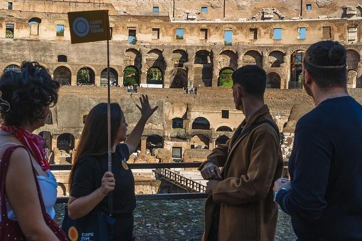 Guide and visitors at a stone-railed main Colosseum overlook
