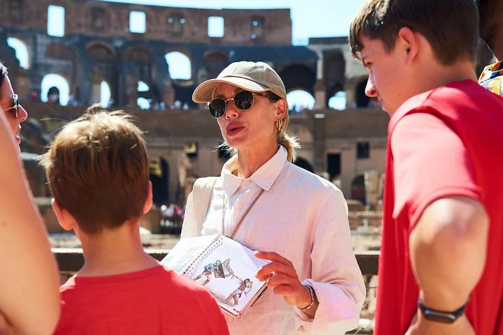 Guide using an illustrated book with young visitors on the arena route