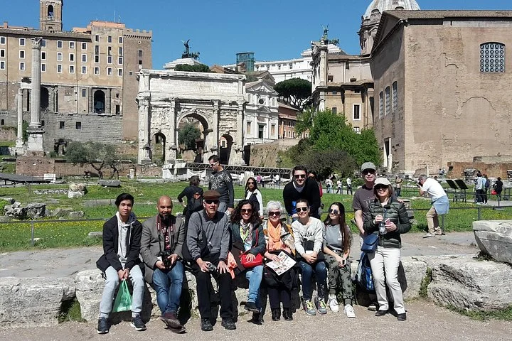 Visitors posing beside the Arch of Septimius Severus