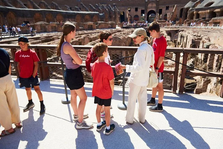 Guide and visitors standing beside the arena platform railing