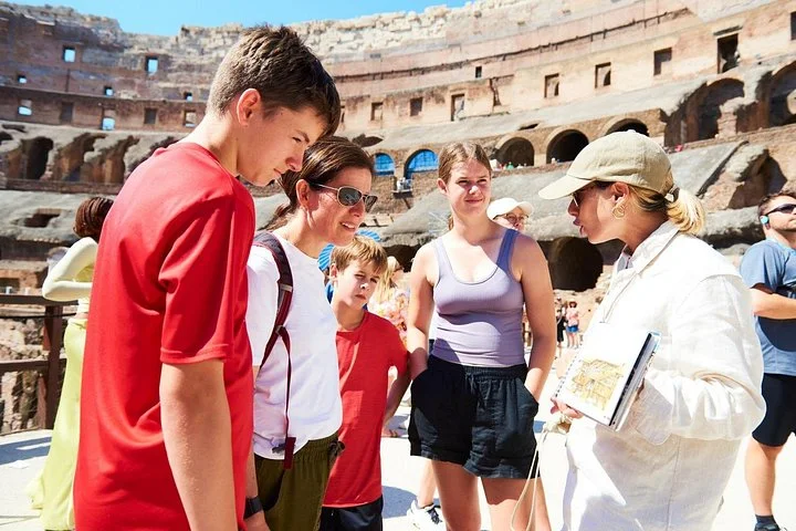 Guide explaining an illustrated book to visitors on the arena route