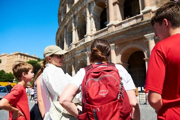 Guide and young visitors beside the Colosseum exterior