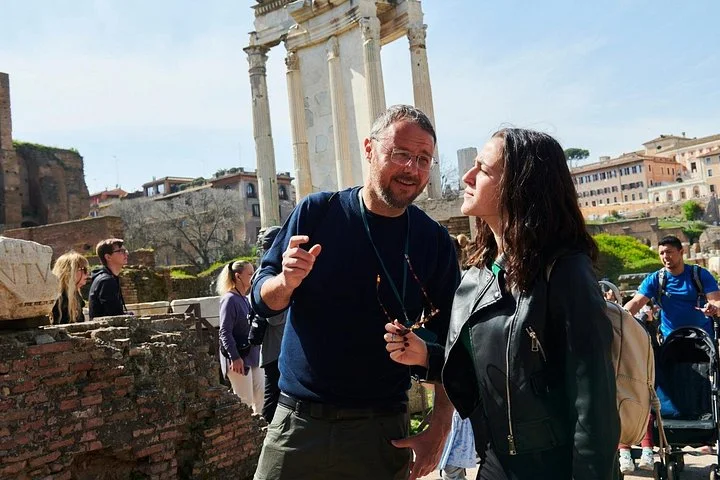 A guide and visitor discuss the ancient temples of the Roman Forum.