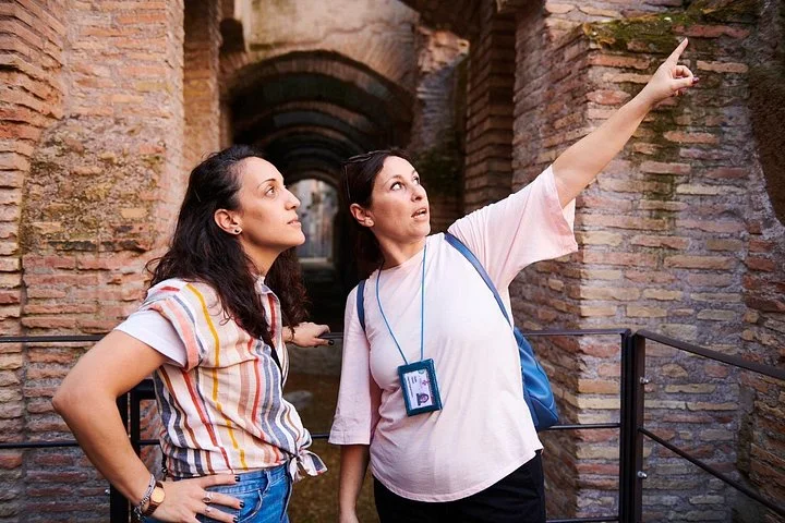 A guide points out brick arches in the Colosseum underground.