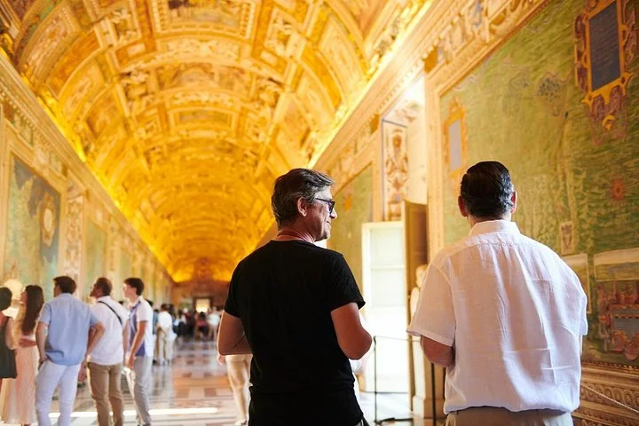 Visitors walking through the illuminated Vatican Gallery of Maps
