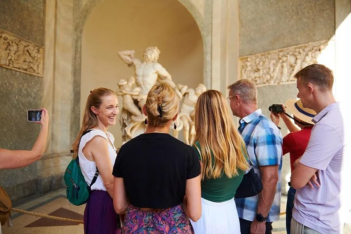 Guide and visitors viewing the Laocoon sculpture in the Vatican Museums