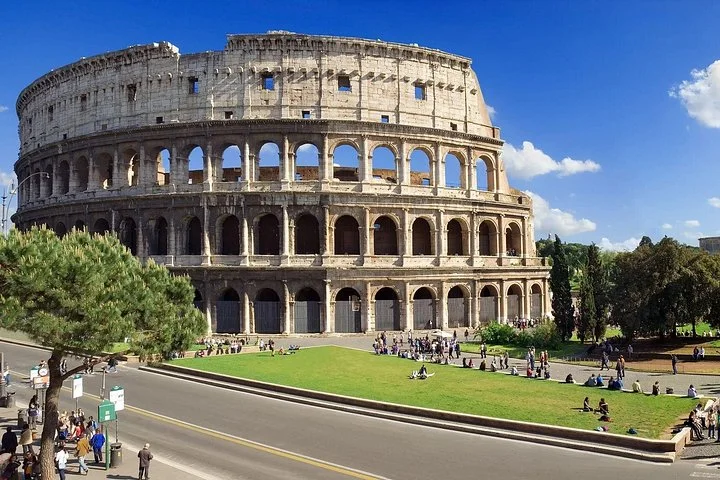 Colosseum exterior with green lawns and blue sky