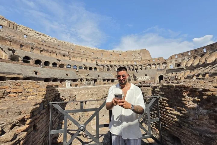 Visitor beside a gated low entrance on the Colosseum arena route