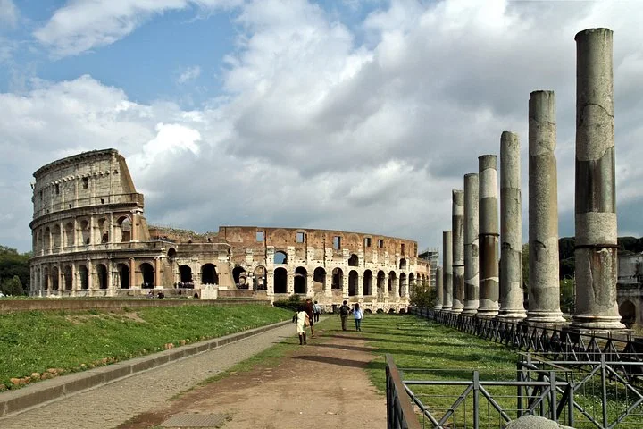 Colosseum exterior beyond a path and ancient columns