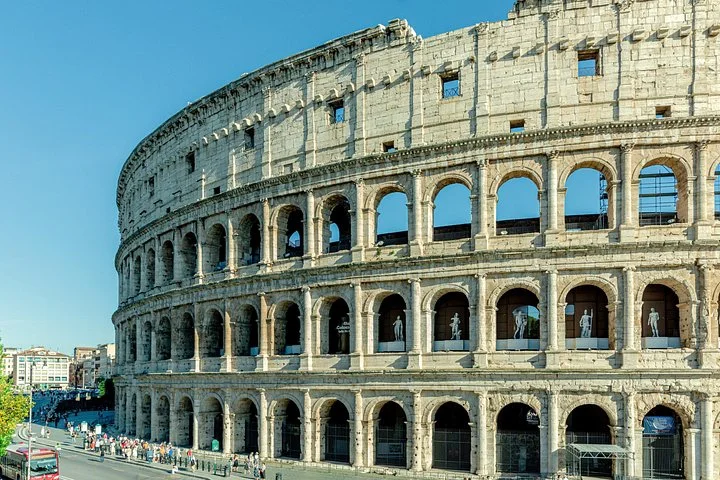 Rows of arches curve around the Colosseum's sunlit exterior.