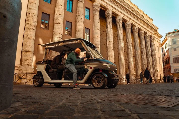 Guide and golf cart beside the Temple of Hadrian columns