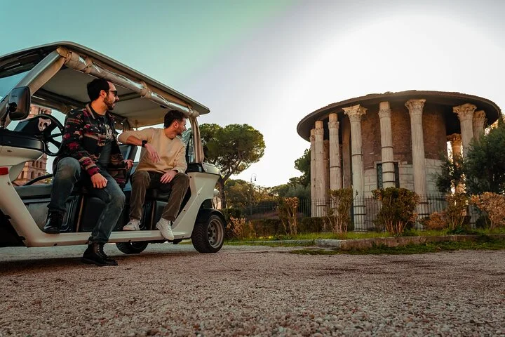 Golf-cart visitors looking toward the round Temple of Hercules Victor