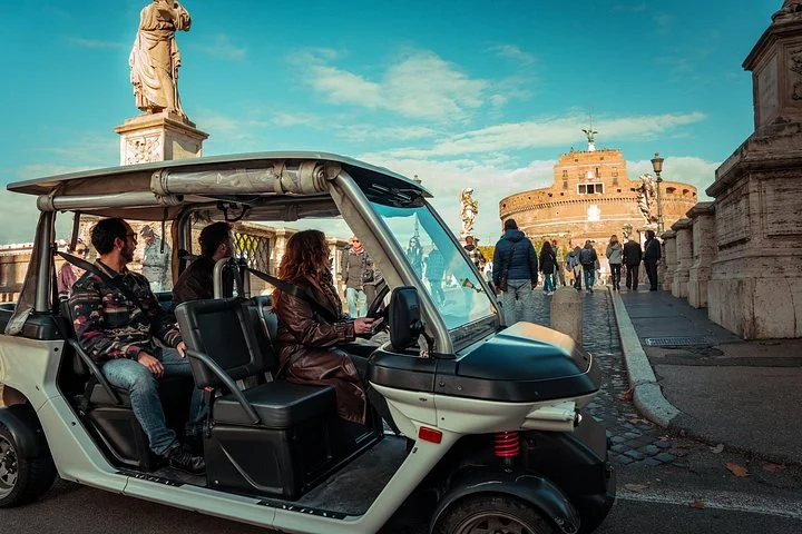Golf cart on a bridge with Castel Sant'Angelo behind it