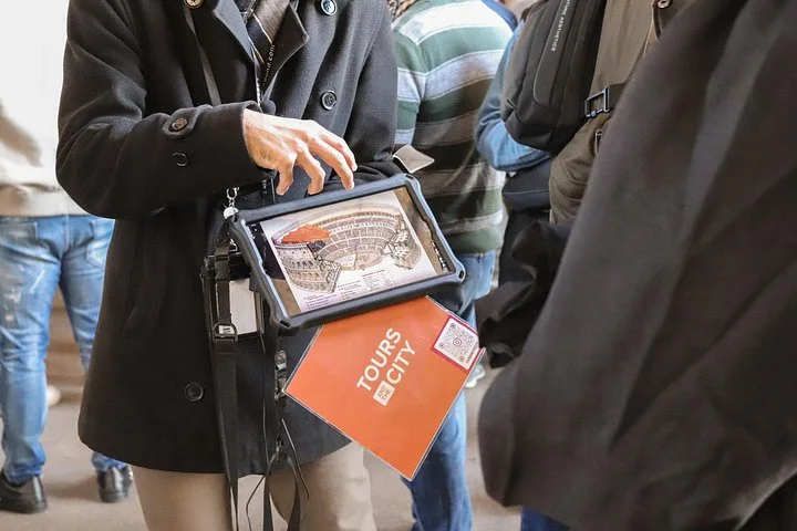Guide showing a Colosseum reconstruction on a tablet