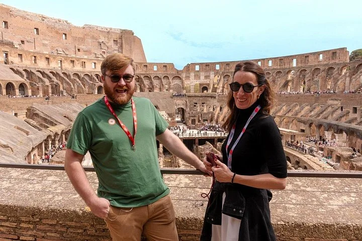 Two visitors at a main-level Colosseum overlook