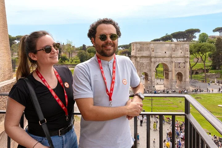 Two visitors with the Arch of Constantine below the Colosseum balcony