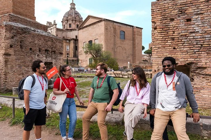 Guide and visitors sitting among Roman Forum brick ruins