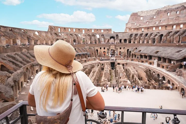 Visitor in a sunhat looking into the Colosseum from a main-level overlook