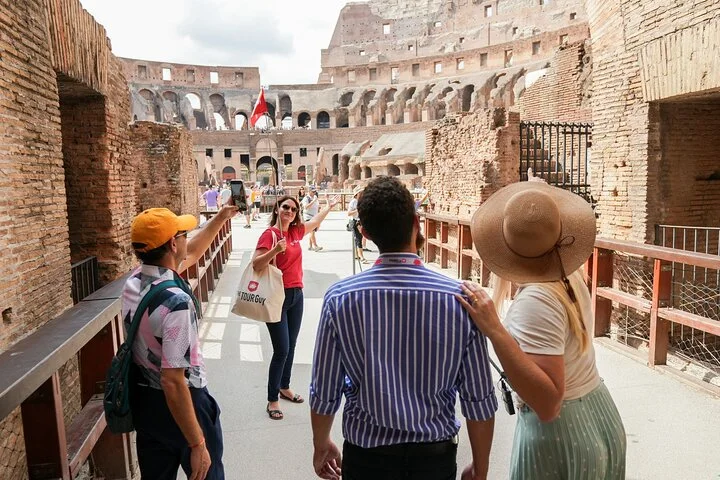Guide and visitors approaching the Colosseum arena platform