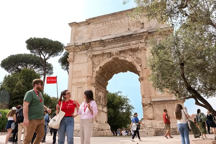 Guide and visitors beside the Arch of Titus