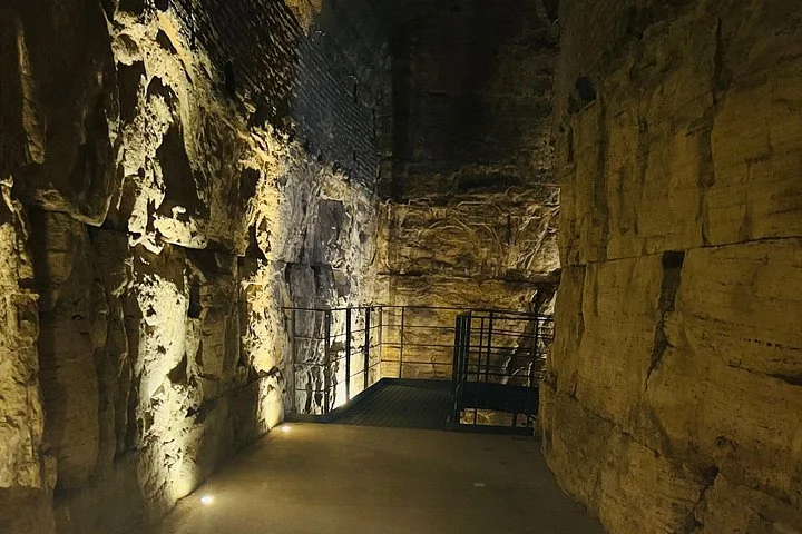 Low lights illuminate a narrow stone passage below the Colosseum arena.