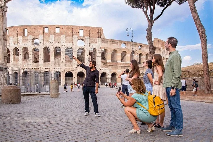 Guide and visitors on the public square outside the Colosseum