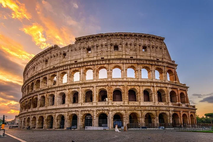 Colosseum exterior beneath an orange evening sky